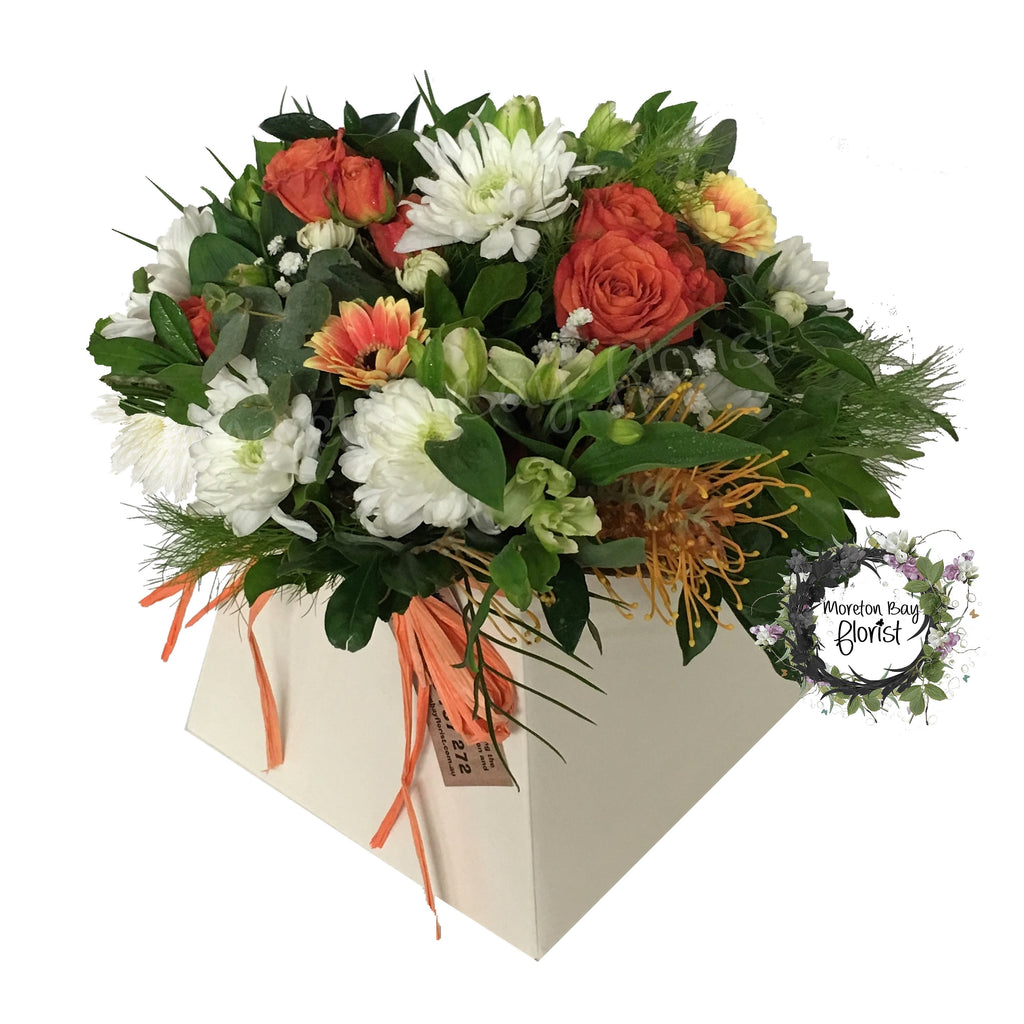 Lush flower arrangement in creams, whites and orange